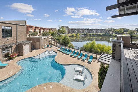 A pool with loungers at Midway Urban Village in Farmers Branch Texas