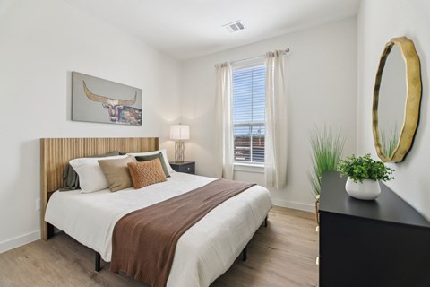 A bedroom with a large bed and a painting of a bull on the wall.