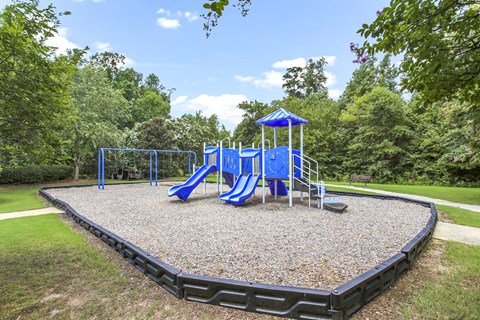 A playground with a blue slide and a blue and white canopy.