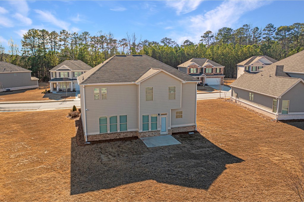 a group of houses in a field with trees in the background