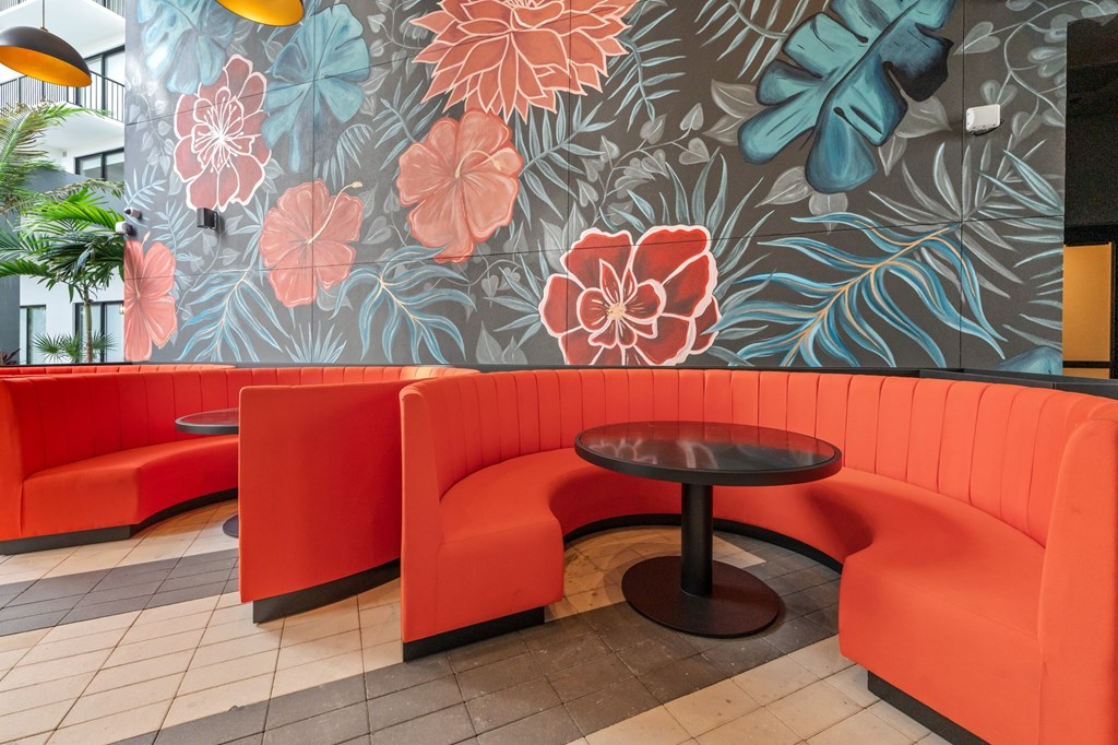 Outdoor Paseo with orange booths and a floral mural on the wall.