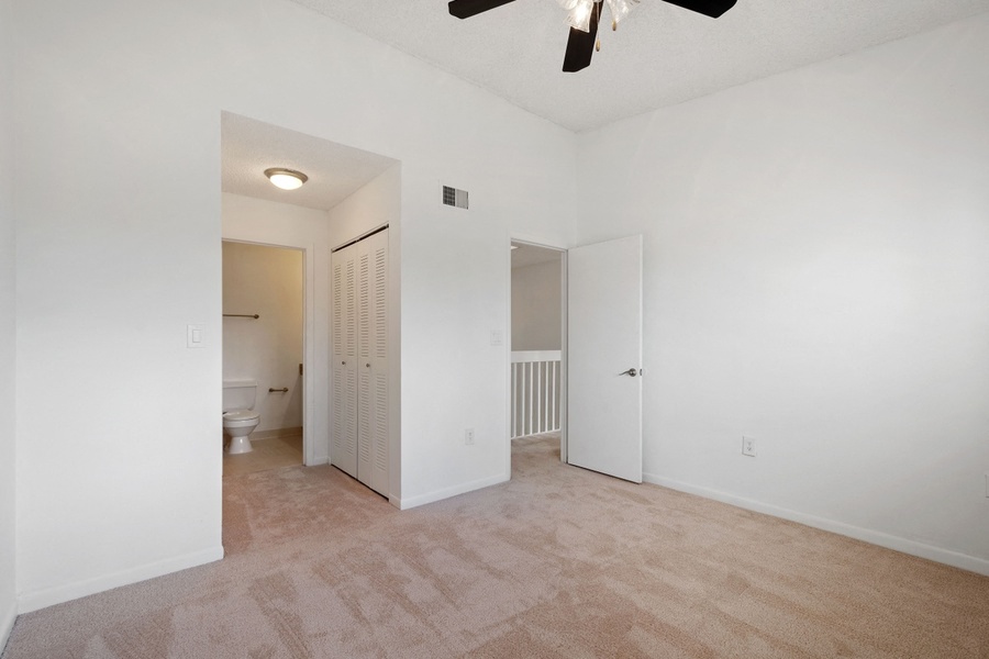 Carpeted bedroom with closet and en suite bathroom