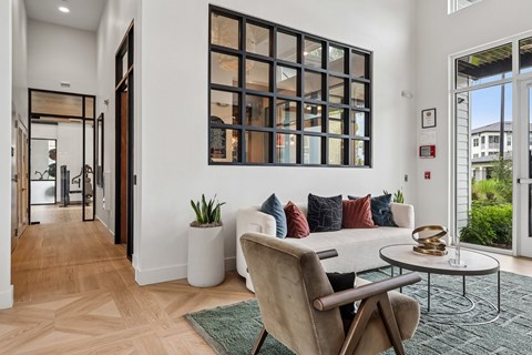 A living room with a chair, a table, and a potted plant.