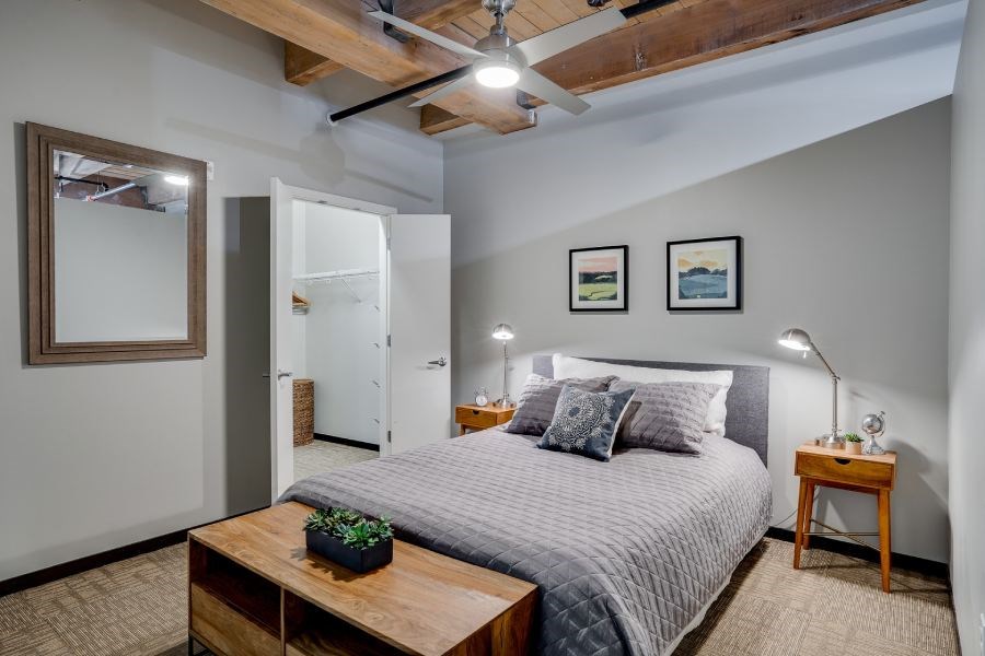 Loft style bedroom with exposed wood ceilings and walk-in closet