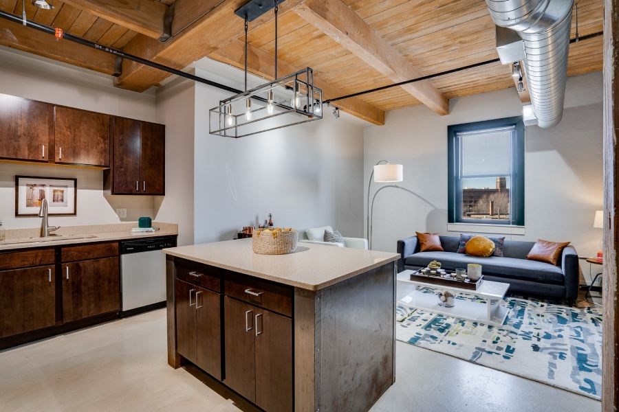Lofts open living area with exposed beams and ducts