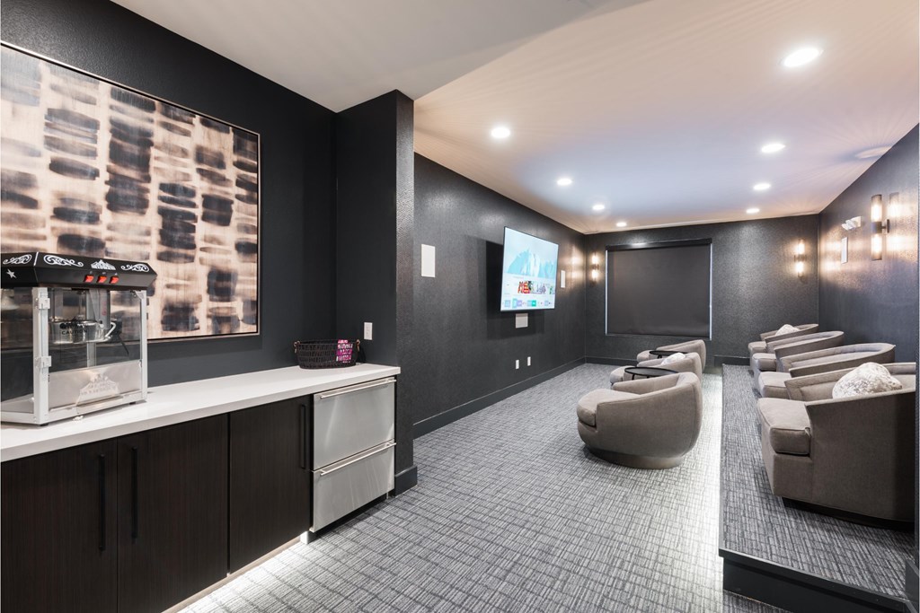 a theater room with couches and chairs and a projector screen