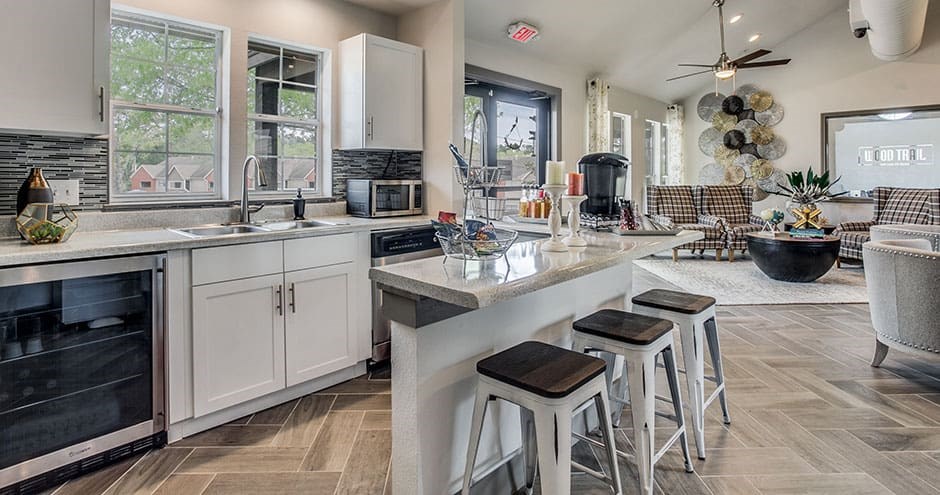a kitchen and living room with stools and a counter