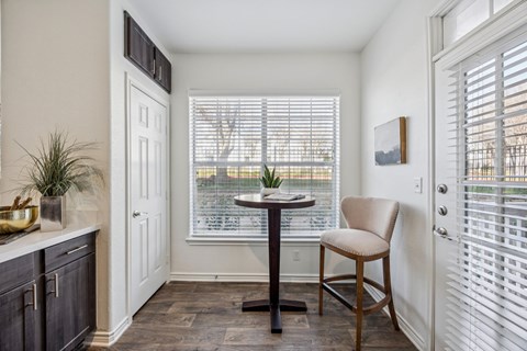 A dining room with a table and chairs.