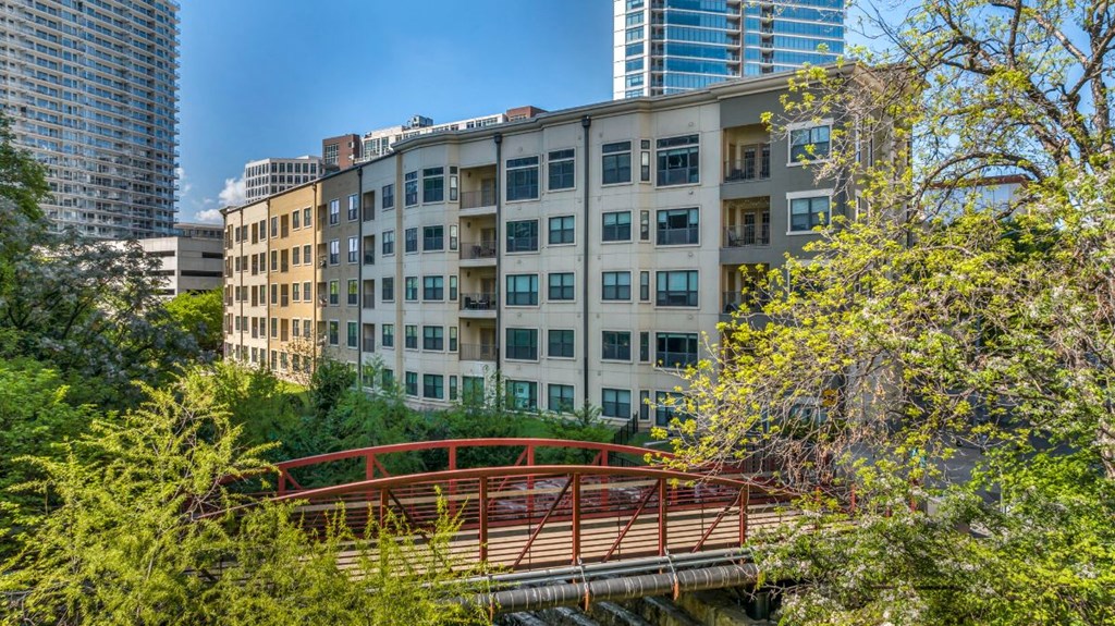 a red bridge in front of an apartment building