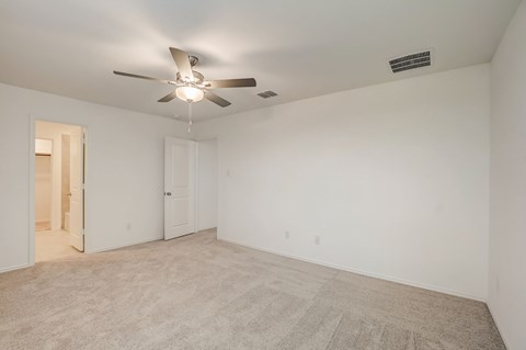 Expansive carpeted bedroom with a significant amount of space, accompanied by the convenience of a private bathroom for exclusive use.