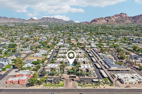 A bird's eye view of a residential area with a road running through the middle.