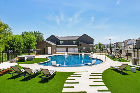A large backyard with a pool and lawn chairs.