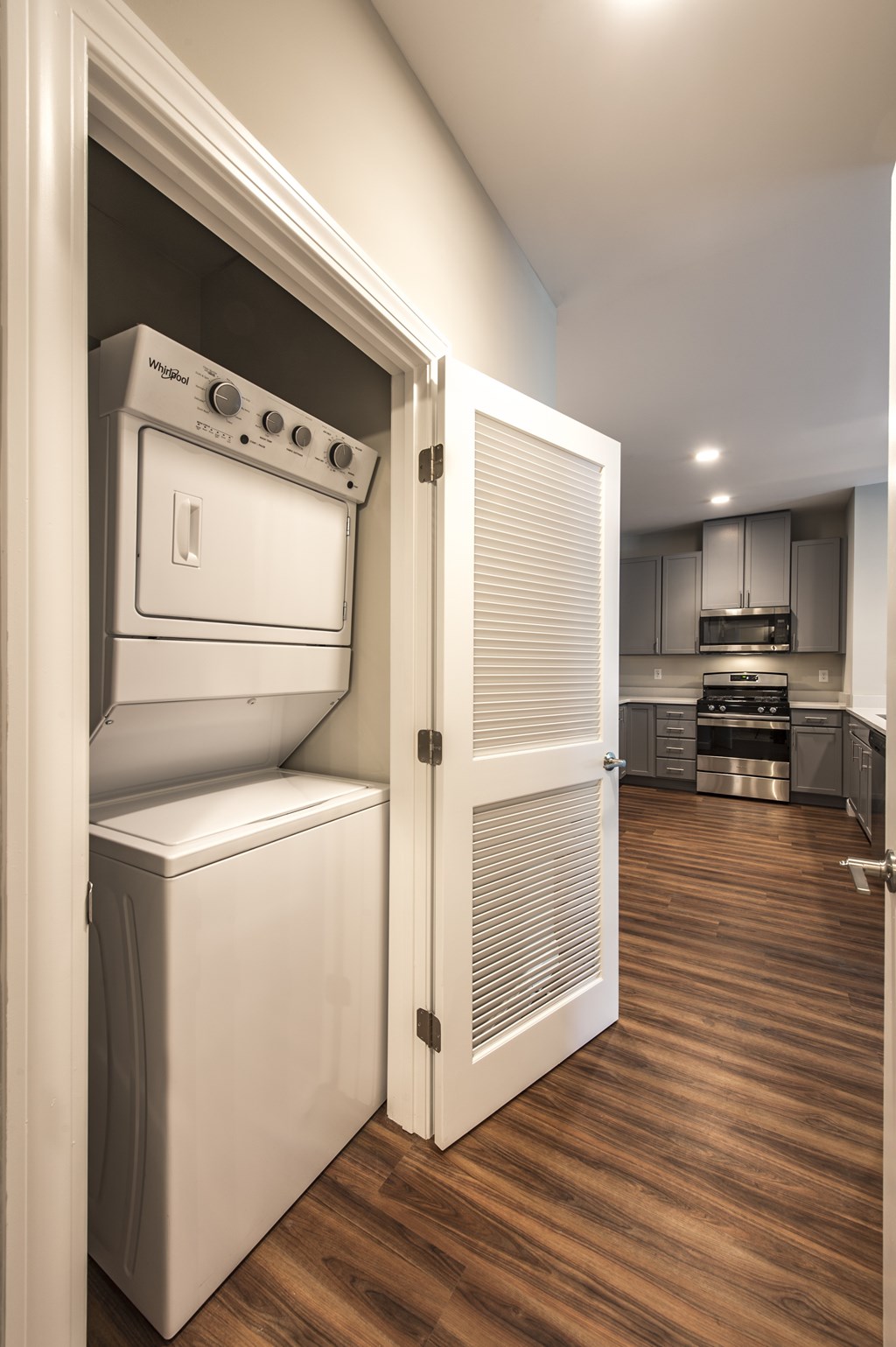 A white oven and dishwasher are in a kitchen with wooden floors.