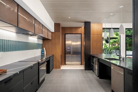 A modern kitchen with a stainless steel refrigerator and black cabinets.