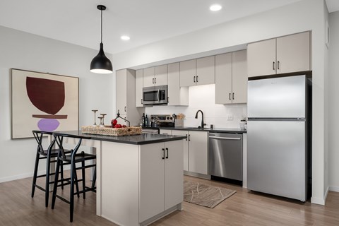 A modern kitchen with a large island and stainless steel appliances.