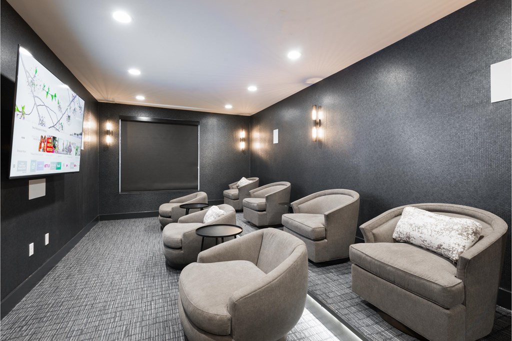 a large screening room with couches and chairs and a tv