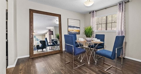 a dining room with a mirror and a table and chairs