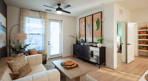 A living room with a white couch and a wooden coffee table.