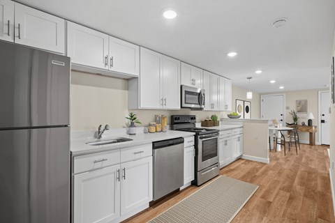 A modern kitchen with white cabinets and stainless steel appliances.