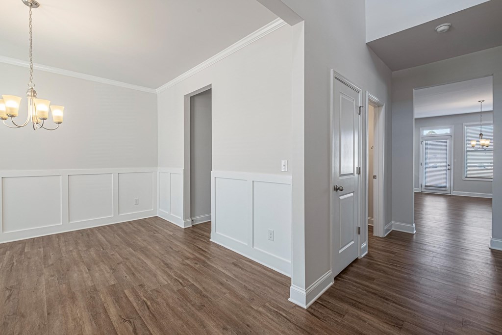an empty living room with wood floors and white walls
