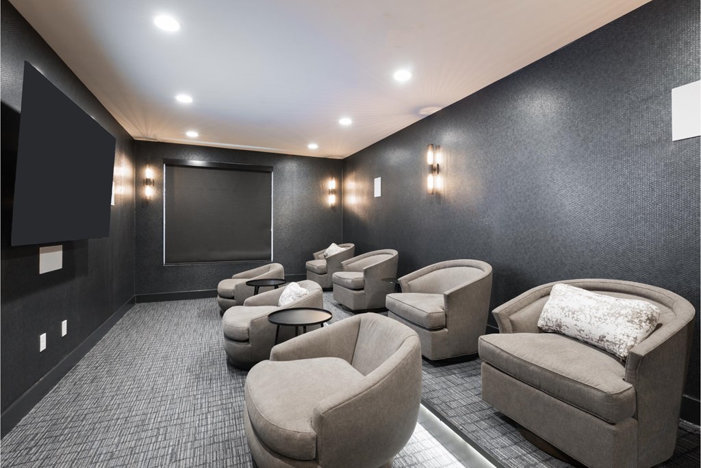 a large screening room with couches and chairs and a tv