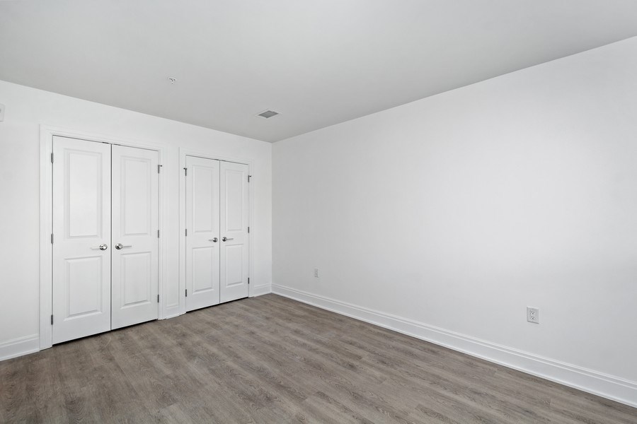 the living room of a house with white walls and wooden floors