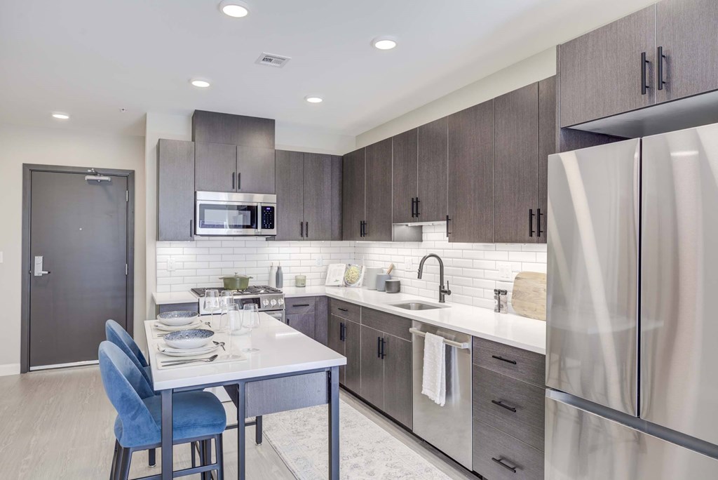 A modern kitchen with a dining table and chairs.