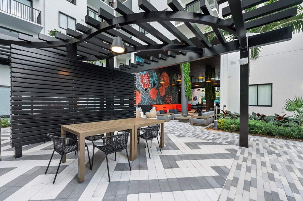 A patio with a table and chairs under a pergola.