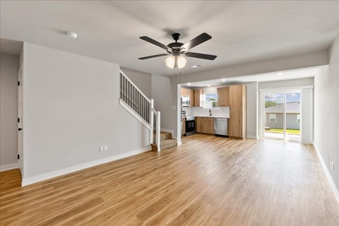 A spacious room with a ceiling fan and wooden flooring.