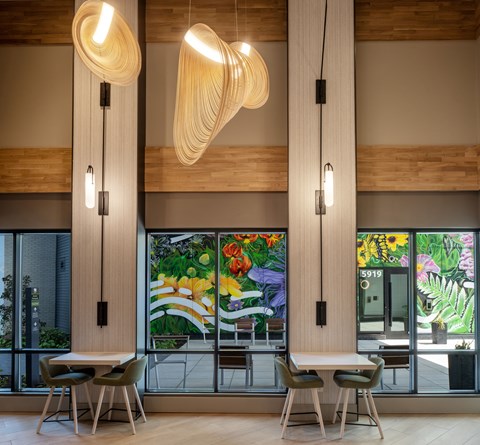 the lobby of a restaurant with tables and chairs and large windows