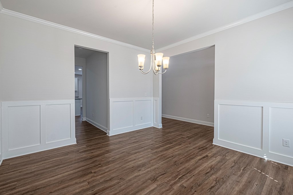 an empty living room with white walls and wood flooring