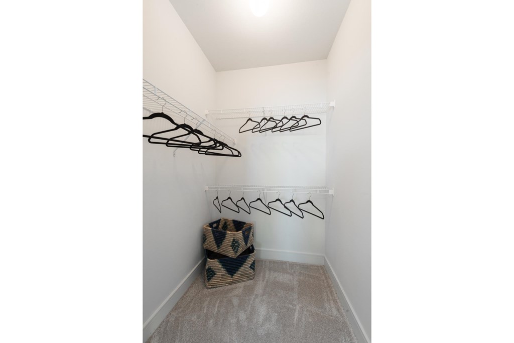 closet in a bedroom with hooks on the wall