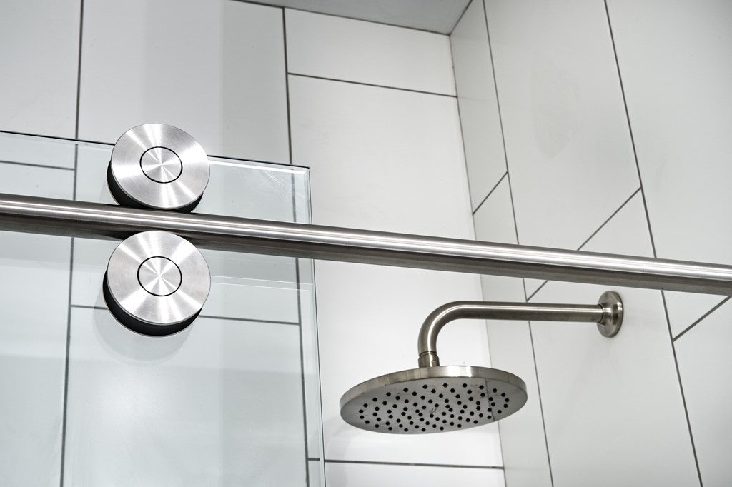 A shower head and hand shower are mounted on a wall.