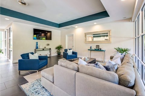 a living room with a gray couch and two blue chairs