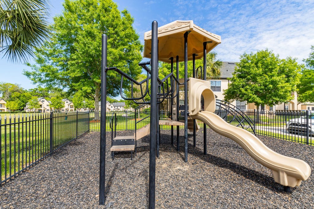 A playground with a slide and a climbing frame.