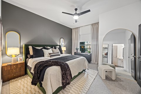 A bedroom with a large bed and a ceiling fan.