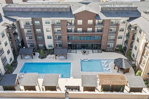 A large apartment complex with a pool in the middle.