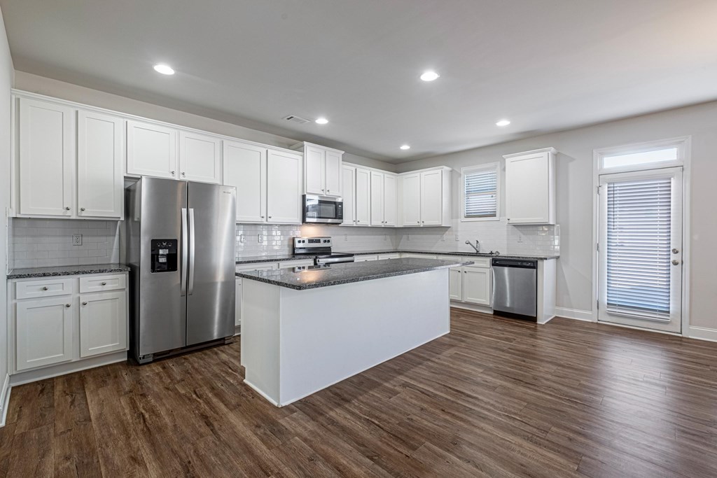 a kitchen with white cabinets and stainless steel appliances