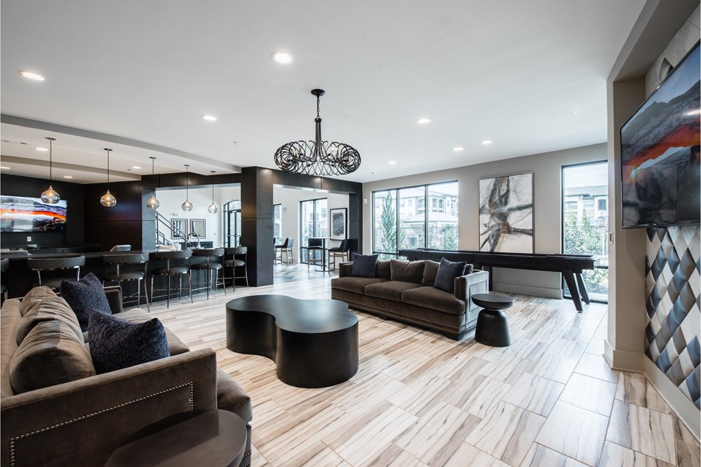 a living room with couches and tables and a piano