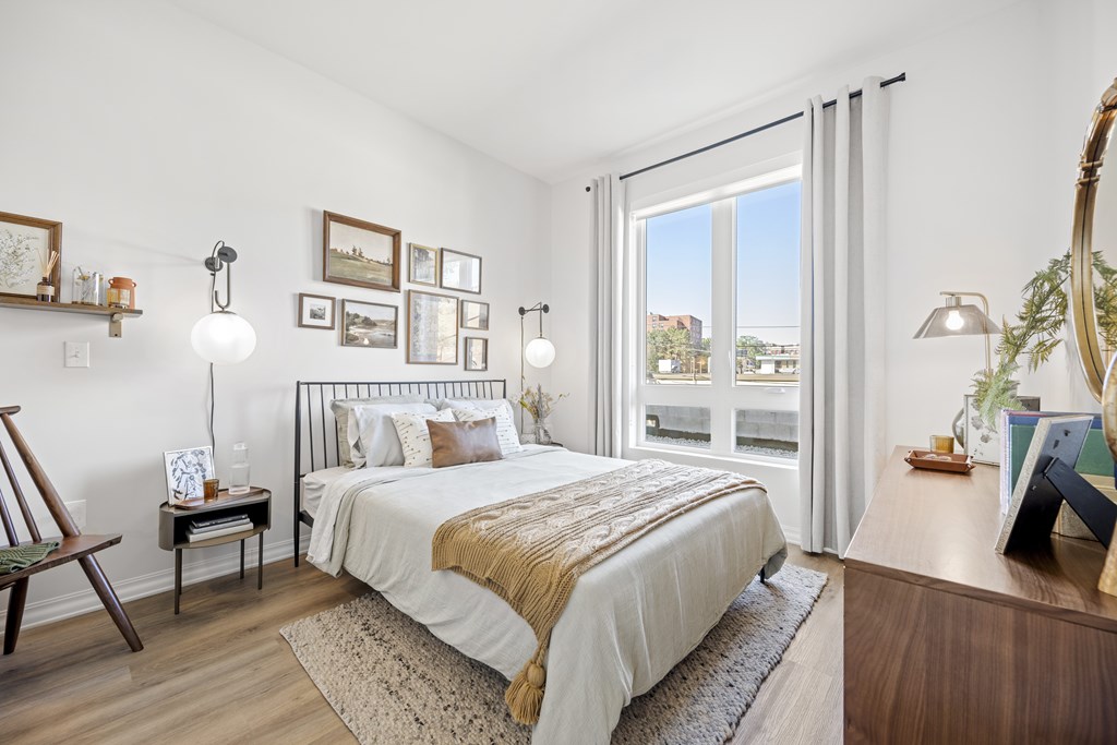 a bedroom with a bed and a large window