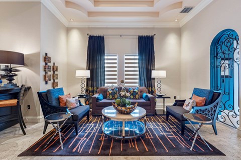 A living room with a large rug and a glass coffee table.