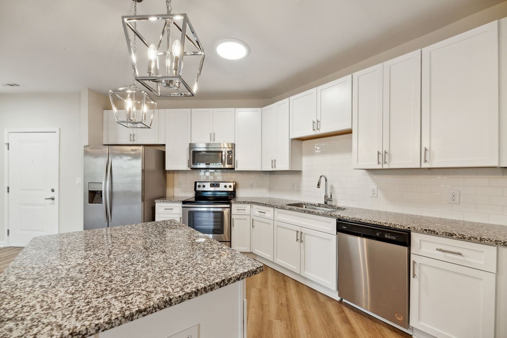 a kitchen with granite counter tops and stainless steel appliances