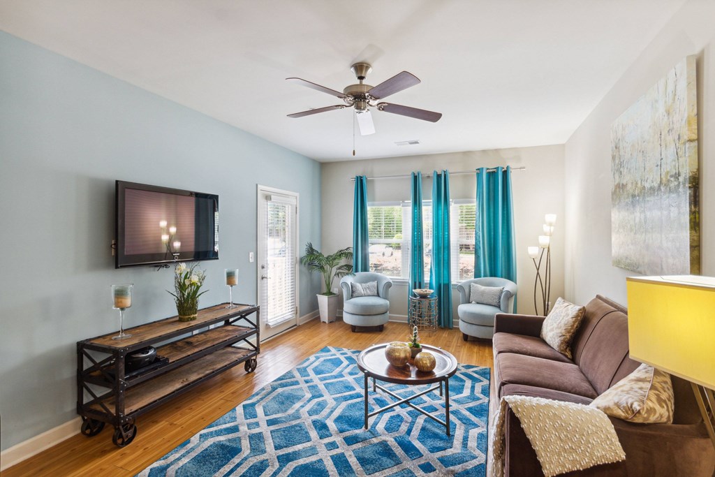 a living room with blue walls and a ceiling fan