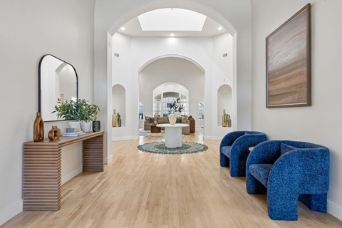 A spacious room with a wooden floor and a large mirror on the left side.