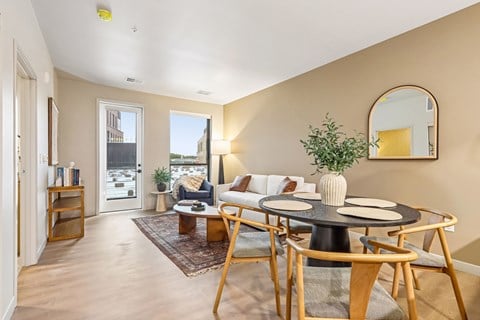 A living room with a round table and chairs.