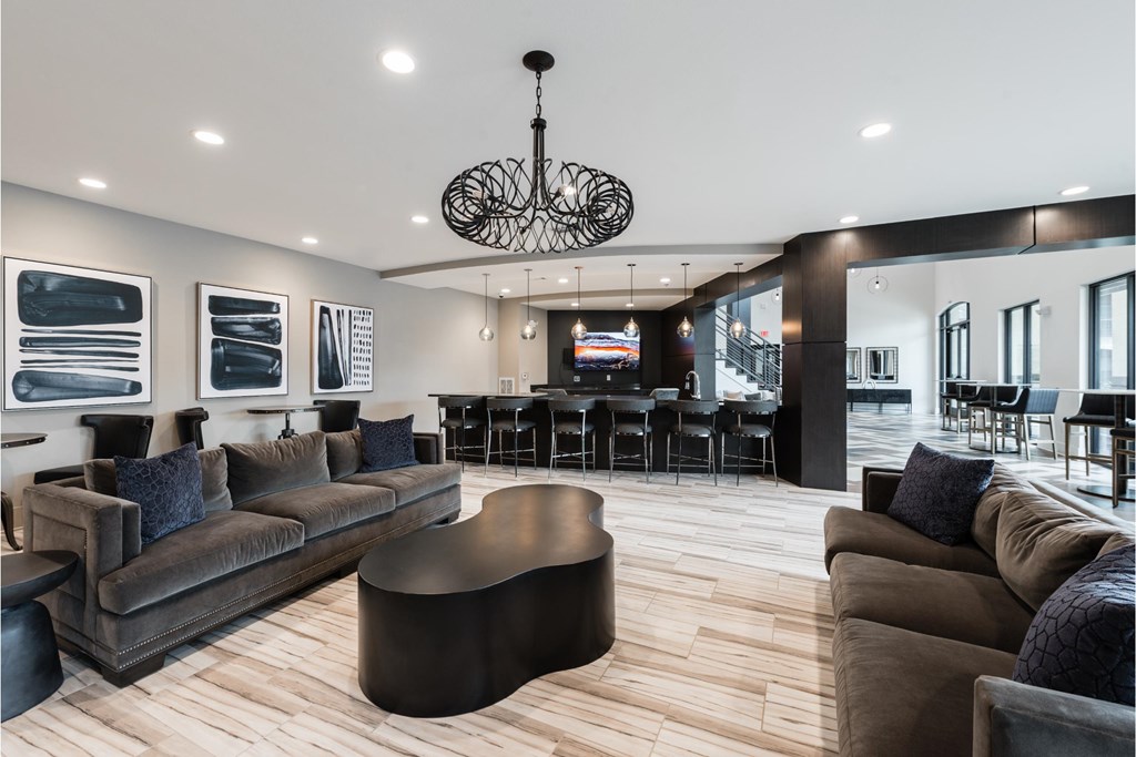 a living room with couches and chairs and a bar