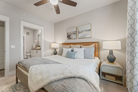 A bedroom with a large bed and a ceiling fan.