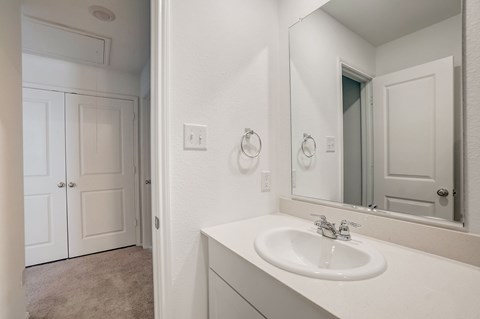 White cabinet bathroom, leading to a bedroom with a walk in closet