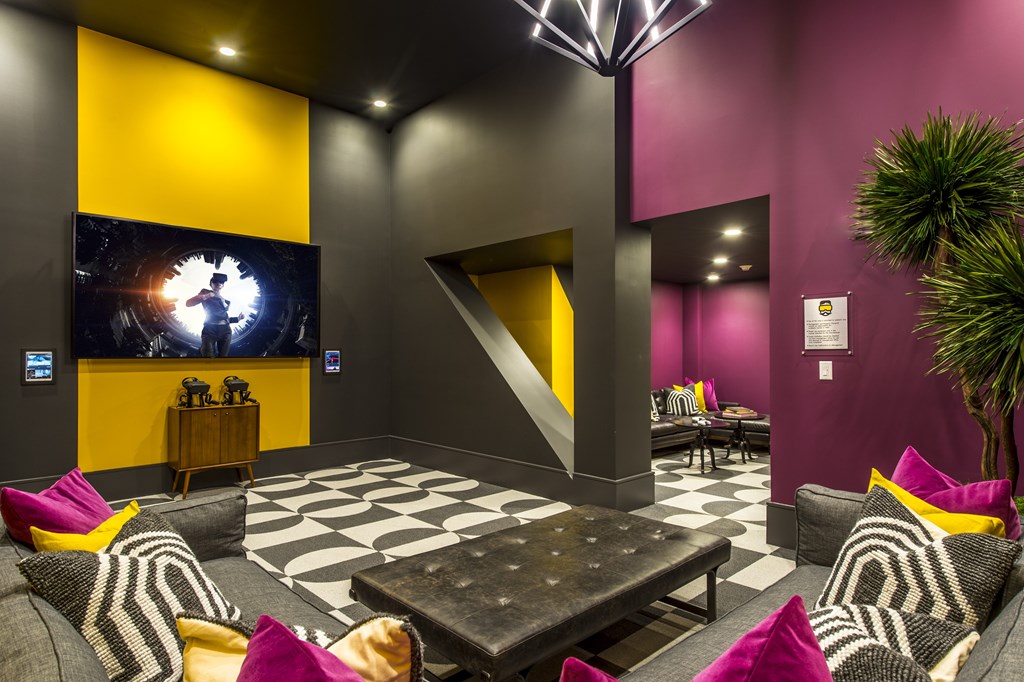 A modern living room with a black and white checkered floor and a large yellow and black artwork on the wall.
