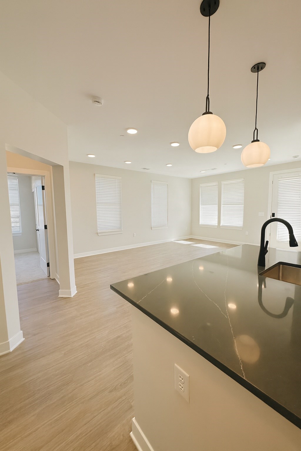 A kitchen with a black counter top and a sink.